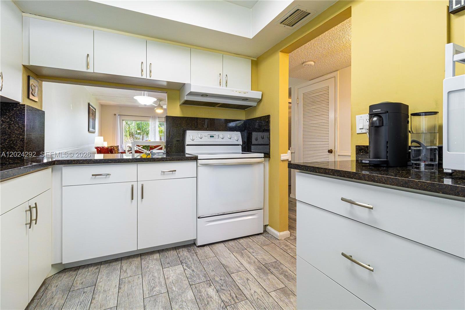 9780 Marina Boulevard, Unit 424 Boca Raton, FL 33428 - Photo 7 of 32 a kitchen with stainless steel appliances granite countertop a sink and cabinets