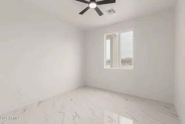an empty room with a ceiling fan and window