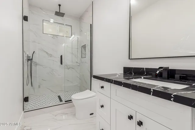 a bathroom with a sink a toilet and shower