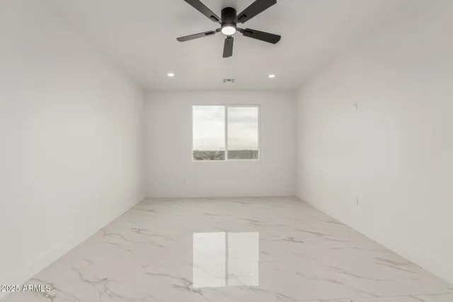 an empty room with a window and a fan