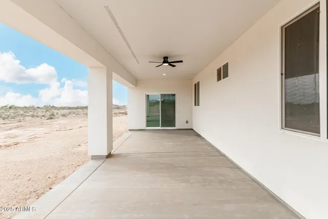 a view of a hallway with wooden floor and a ceiling fan