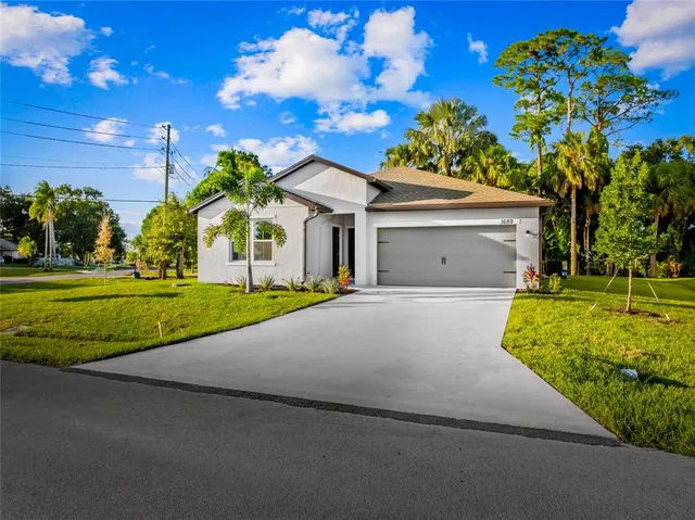 a front view of a house with a yard and a garage