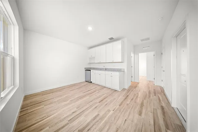 a view of a kitchen with wooden floor and white doors