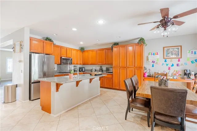 a kitchen with stainless steel appliances a stove a refrigerator a dining table and chairs
