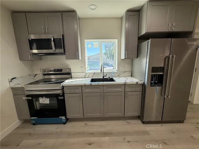 a kitchen with stainless steel appliances granite countertop a refrigerator stove and microwave
