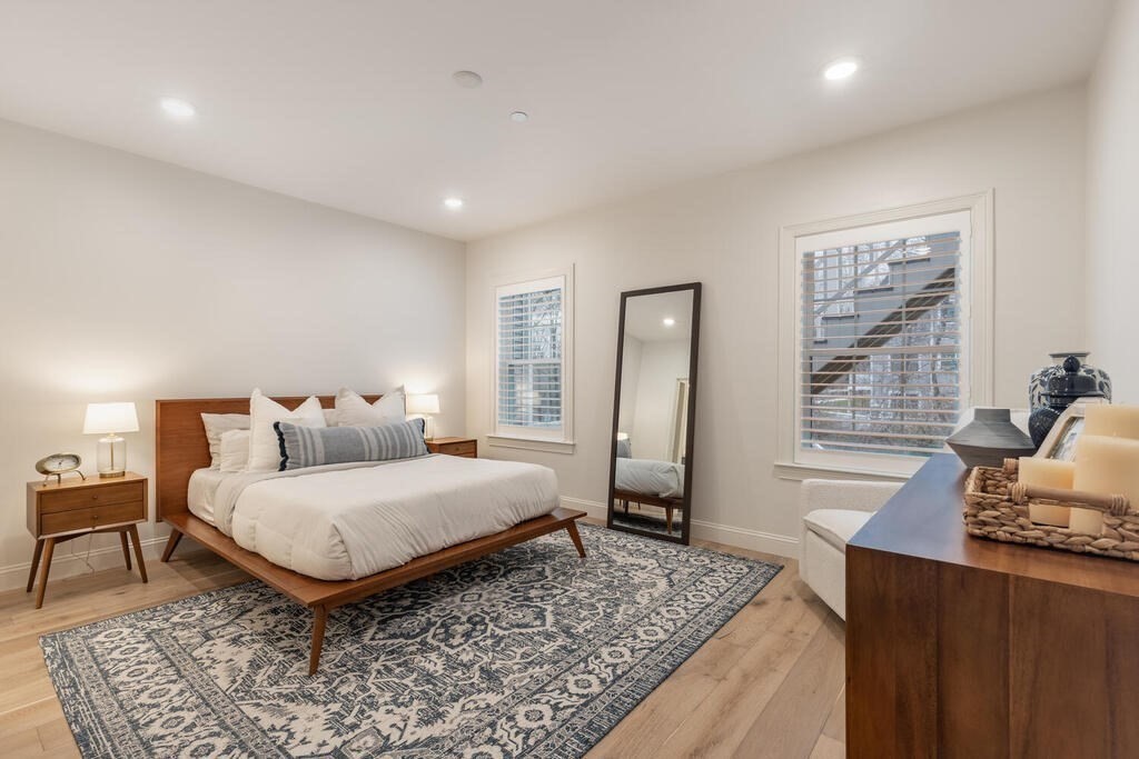 165 Cambridge Road, Unit 10 Woburn, MA 01801 - Photo 13 of 33 a bedroom with a bed and wooden floor