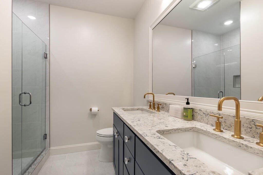 165 Cambridge Road, Unit 10 Woburn, MA 01801 - Photo 15 of 33 a bathroom with a granite countertop sink and a mirror