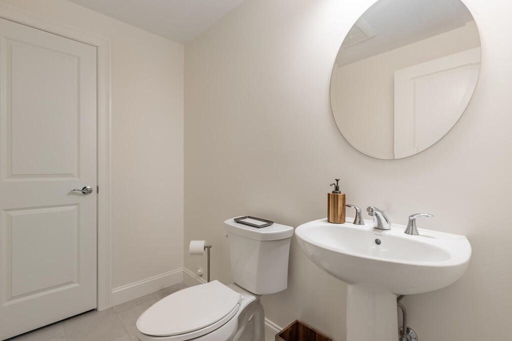 165 Cambridge Road, Unit 10 Woburn, MA 01801 - Photo 25 of 33 a bathroom with a toilet a sink and a mirror