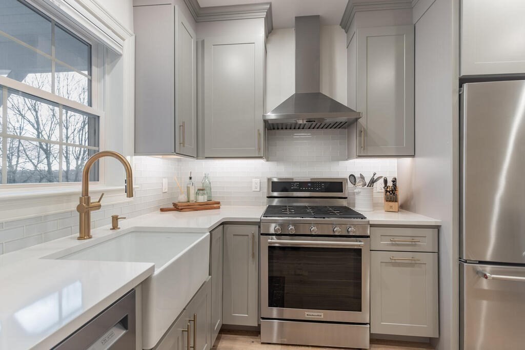165 Cambridge Road, Unit 10 Woburn, MA 01801 - Photo 3 of 33 a kitchen with stainless steel appliances granite countertop a sink stove and refrigerator