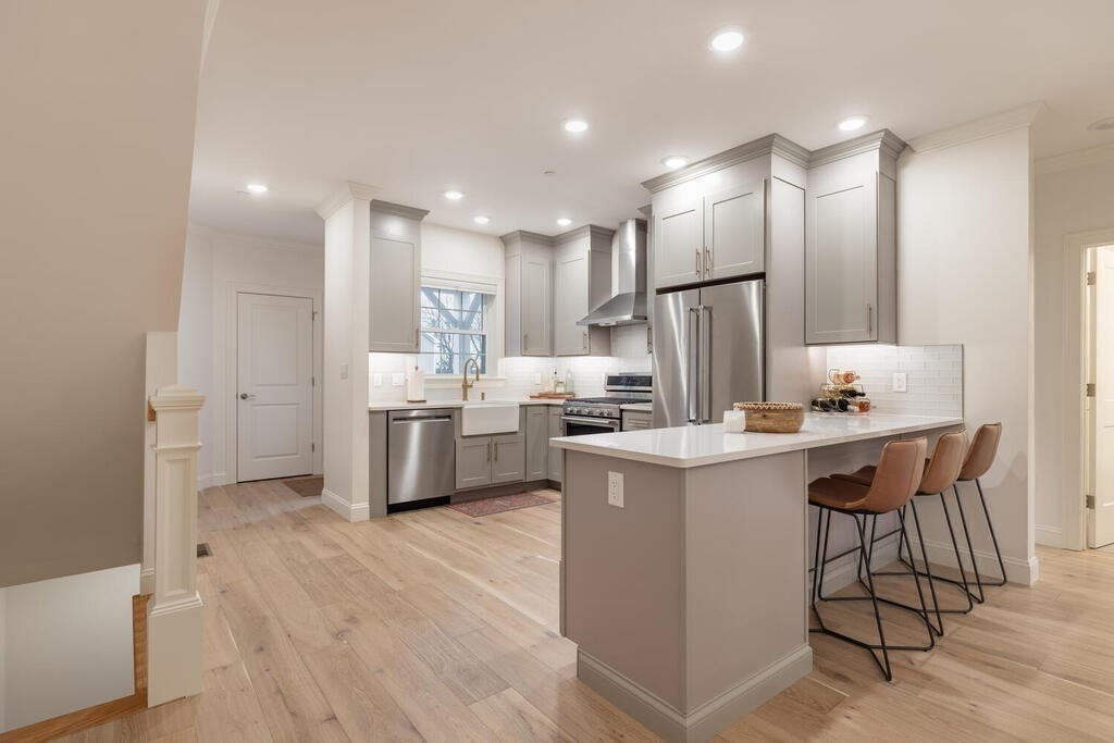 165 Cambridge Road, Unit 10 Woburn, MA 01801 - Photo 5 of 33 a kitchen with stainless steel appliances kitchen island a sink a stove a refrigerator and cabinets