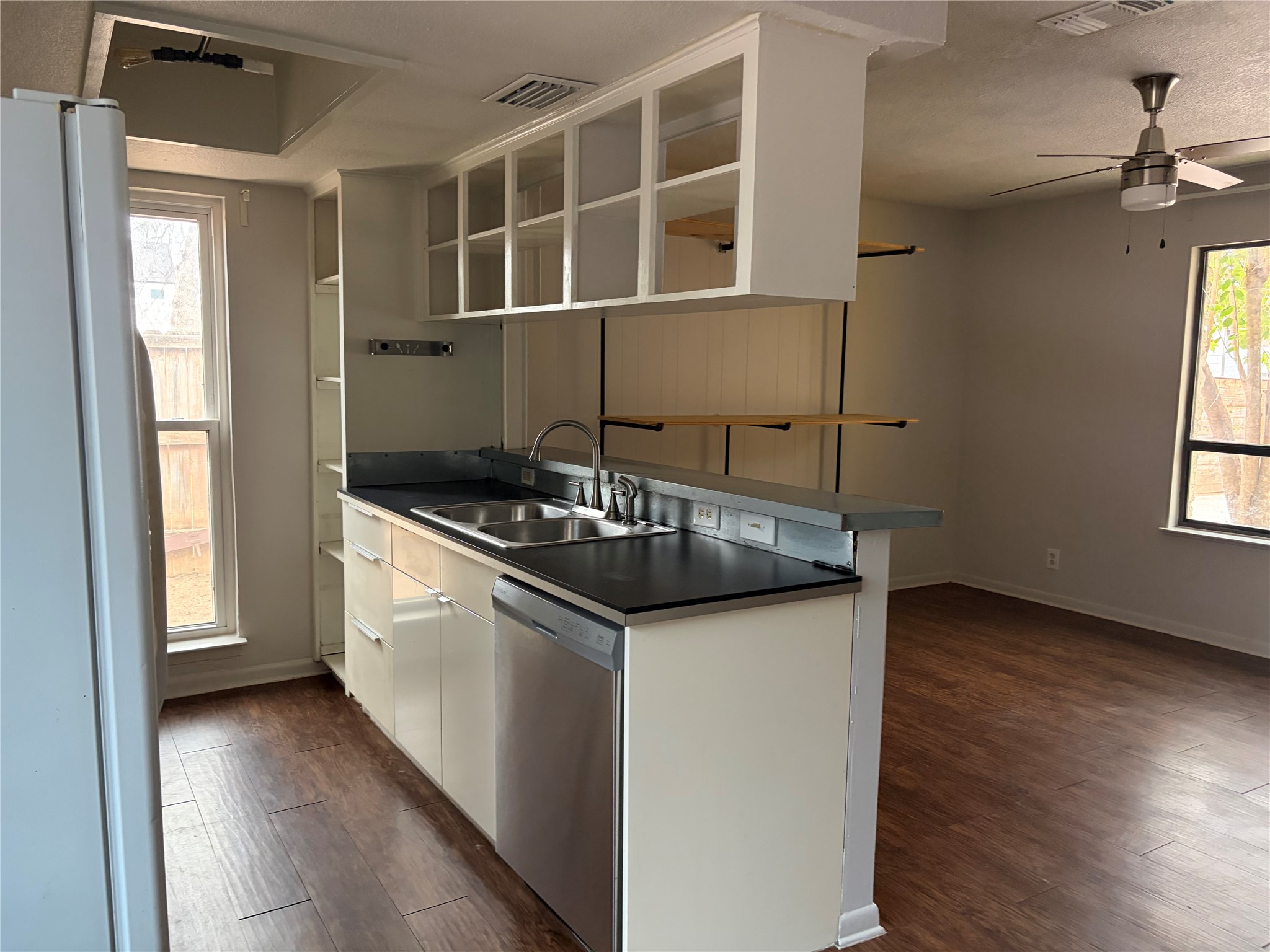 7404 Bethune Avenue, Unit B Austin, TX 78752 - Photo 7 of 13 Kitchen featuring white cabinetry, freestanding refrigerator, ceiling fan, dishwasher, and dark countertops