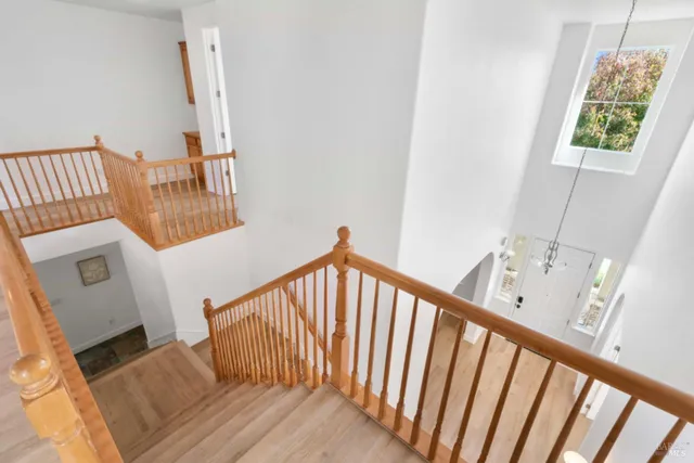 a view of a hallway with wooden floor and staircase