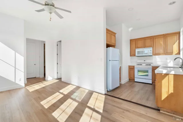 an empty room with a window and ceiling fan