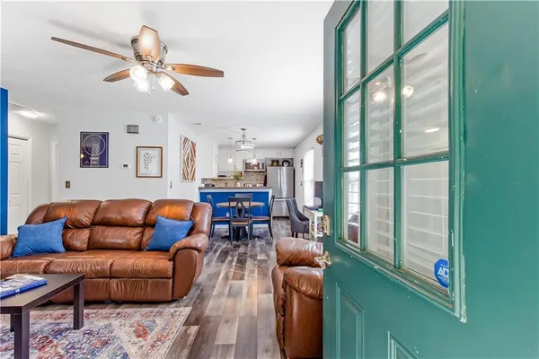 a living room with furniture a ceiling fan and a window