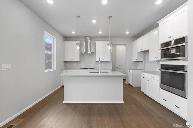 a large kitchen with kitchen island a sink stainless steel appliances and cabinets