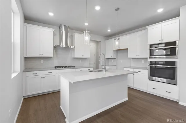 a kitchen with kitchen island granite countertop a sink stainless steel appliances and cabinets