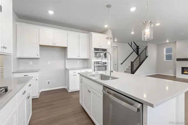 a kitchen with white cabinets appliances and sink