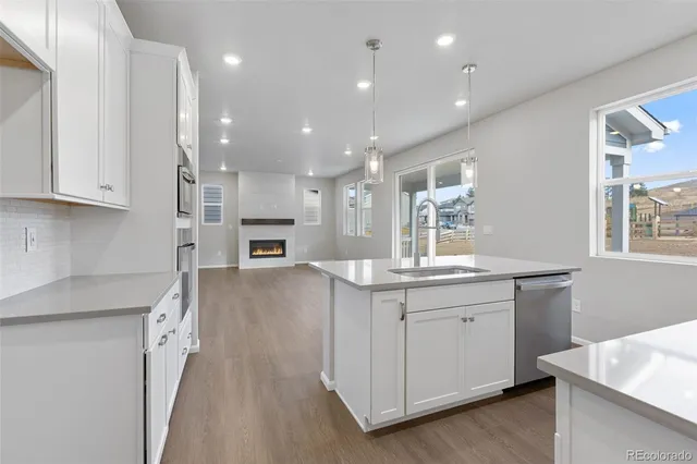 a open kitchen with kitchen island a sink dishwasher stove and oven with wooden floor