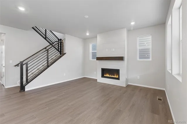 a view of a livingroom with wooden floor and a fireplace