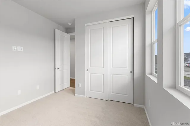 a view of a hallway with wooden floor and windows