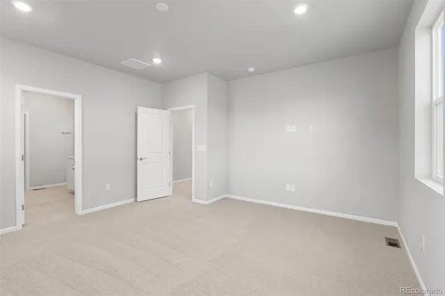 an empty room with windows and closet