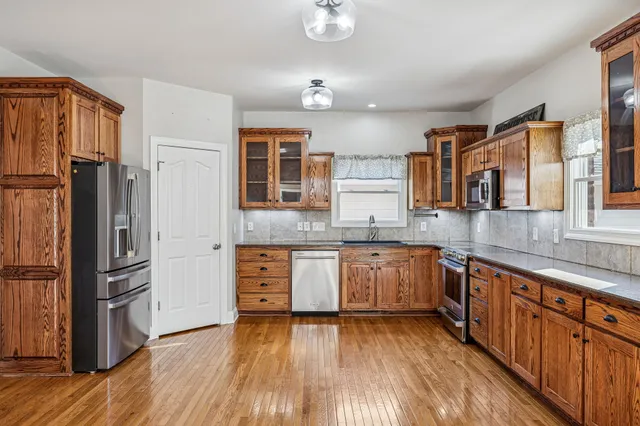 a kitchen with stainless steel appliances granite countertop a refrigerator and a sink