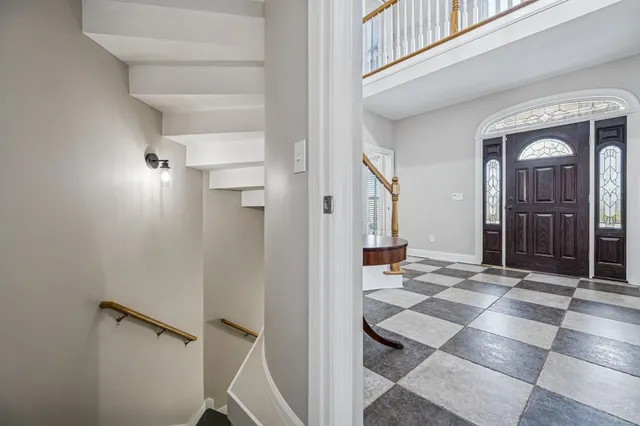 a view of a hallway with wooden floor and a living room