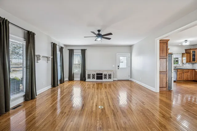 a view of a livingroom with wooden floor and a ceiling fan