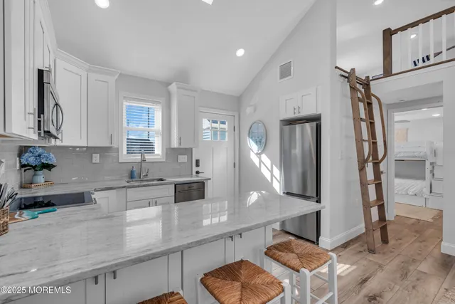 a kitchen with stainless steel appliances granite countertop a sink a stove and a refrigerator