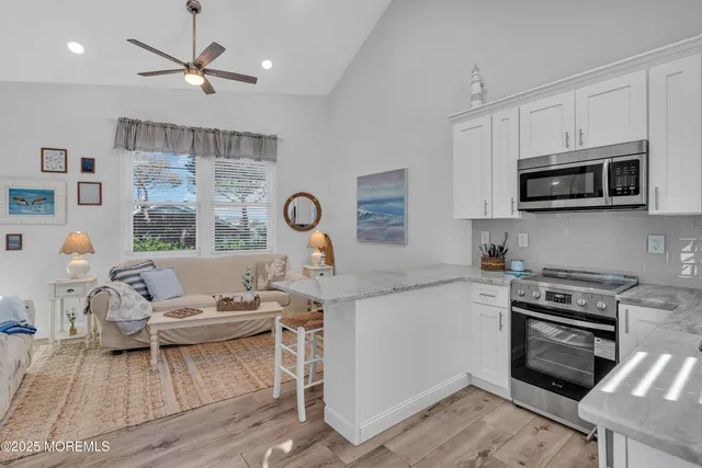 a living room with furniture a rug and kitchen view