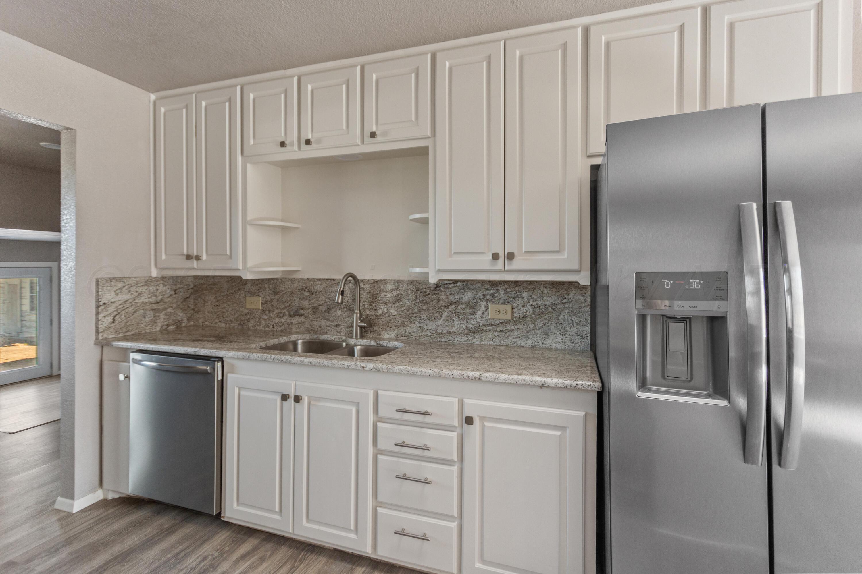 1119 South Main Street Wheeler, TX 79096 - Photo 12 of 49 a kitchen with granite countertop a refrigerator sink and cabinets