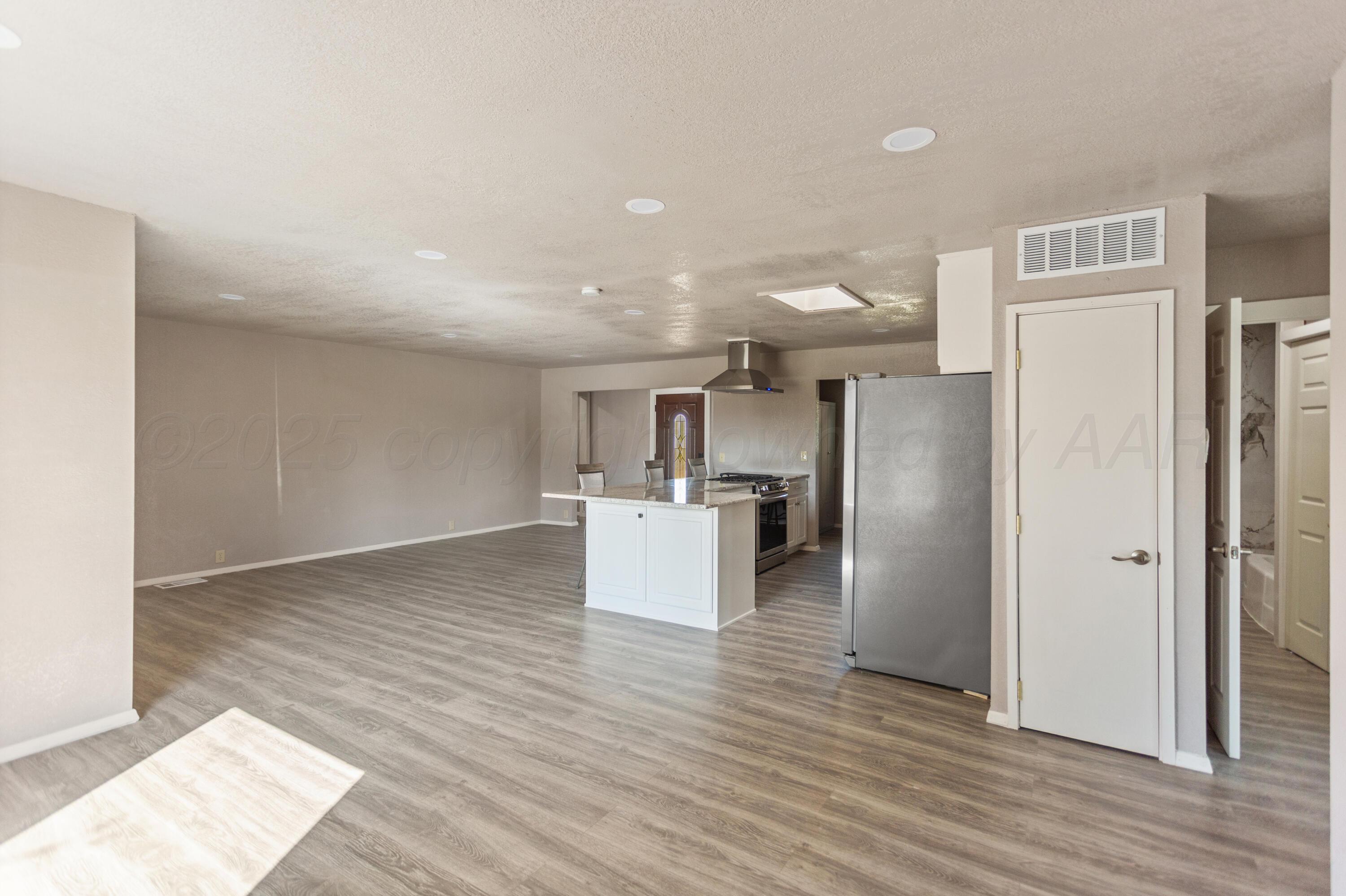 1119 South Main Street Wheeler, TX 79096 - Photo 14 of 49 a kitchen with stainless steel appliances kitchen island wooden floors and refrigerator