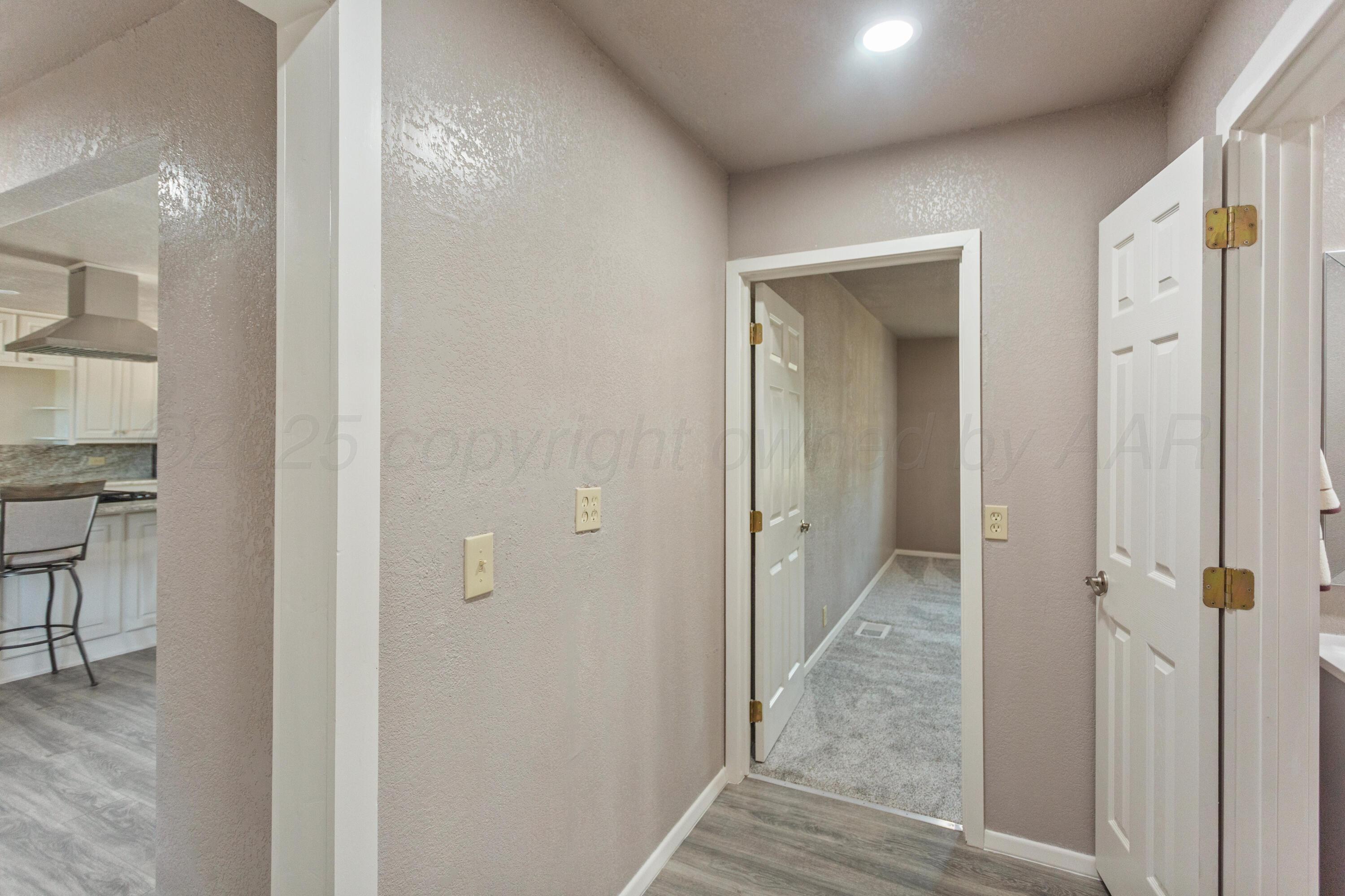1119 South Main Street Wheeler, TX 79096 - Photo 17 of 49 a view of a hallway with wooden floor and a bathroom