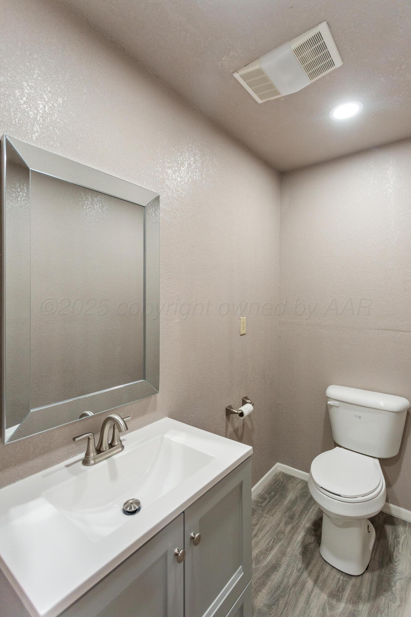 1119 South Main Street Wheeler, TX 79096 - Photo 22 of 49 a bathroom with a toilet sink and mirror