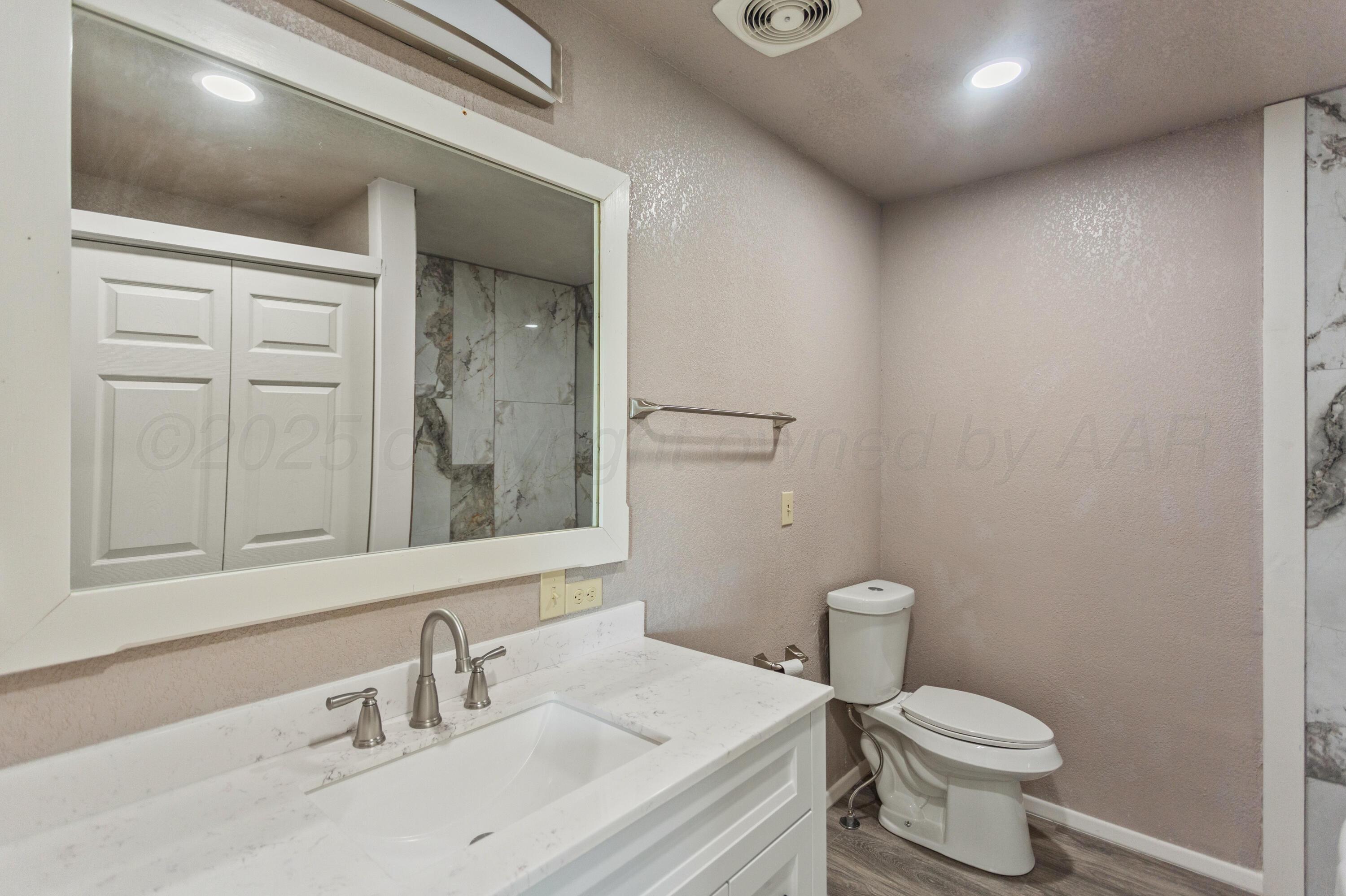 1119 South Main Street Wheeler, TX 79096 - Photo 26 of 49 a bathroom with a sink vanity mirror and toilet