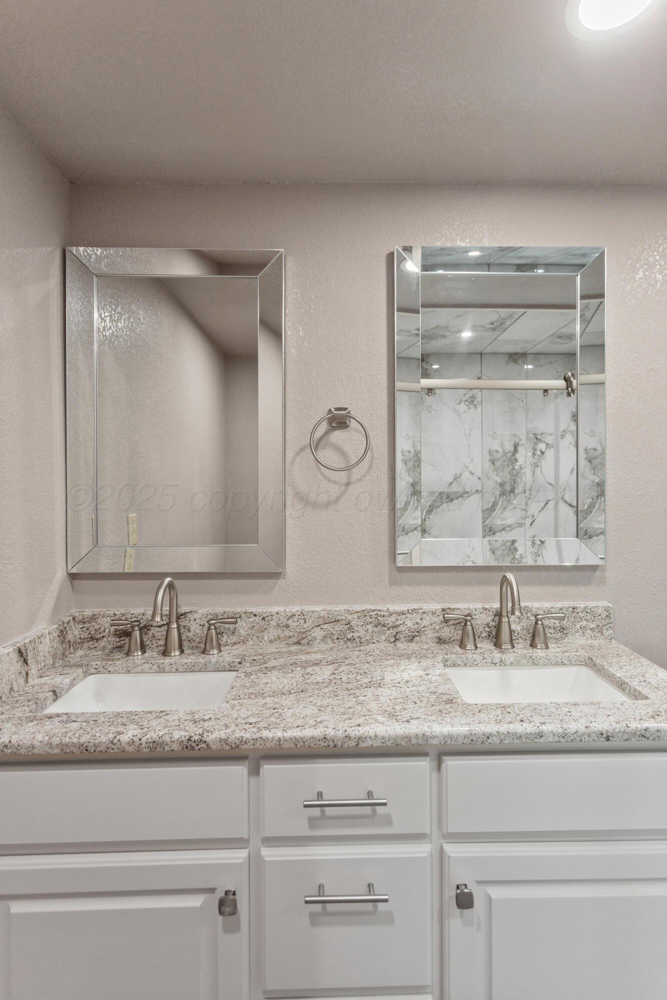 1119 South Main Street Wheeler, TX 79096 - Photo 32 of 49 a bathroom with a granite countertop sink and mirror