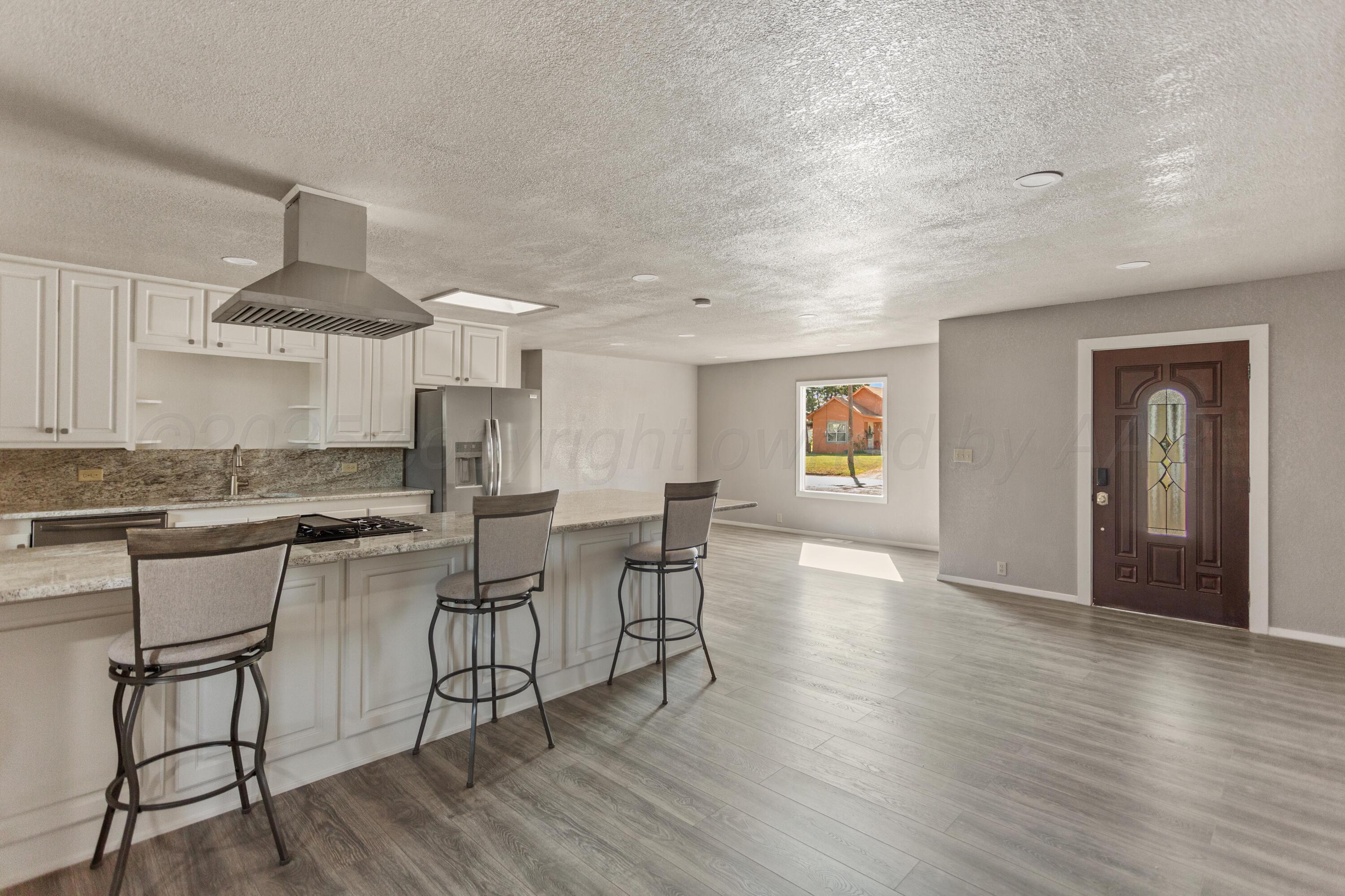 1119 South Main Street Wheeler, TX 79096 - Photo 5 of 49 a kitchen with stainless steel appliances a dining table chairs stove and cabinets