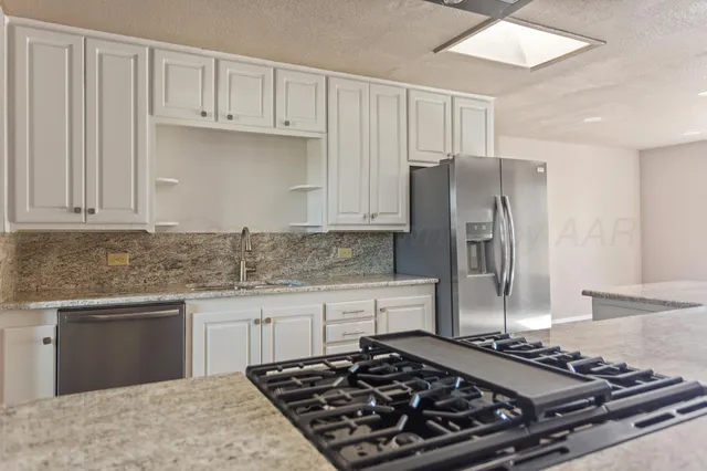 a kitchen with stainless steel appliances granite countertop a sink and stove