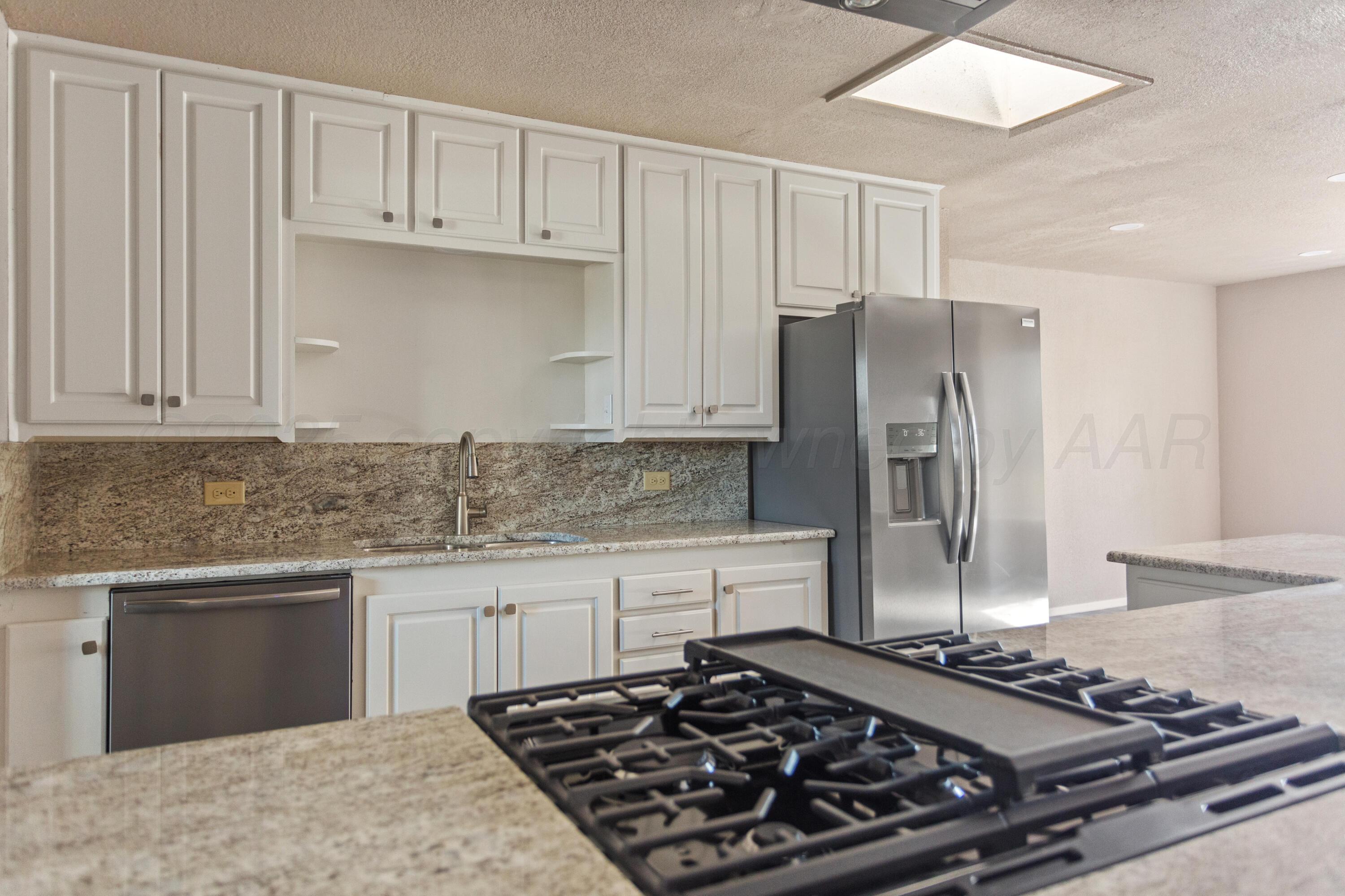 1119 South Main Street Wheeler, TX 79096 - Photo 7 of 49 a kitchen with stainless steel appliances granite countertop a stove and a refrigerator