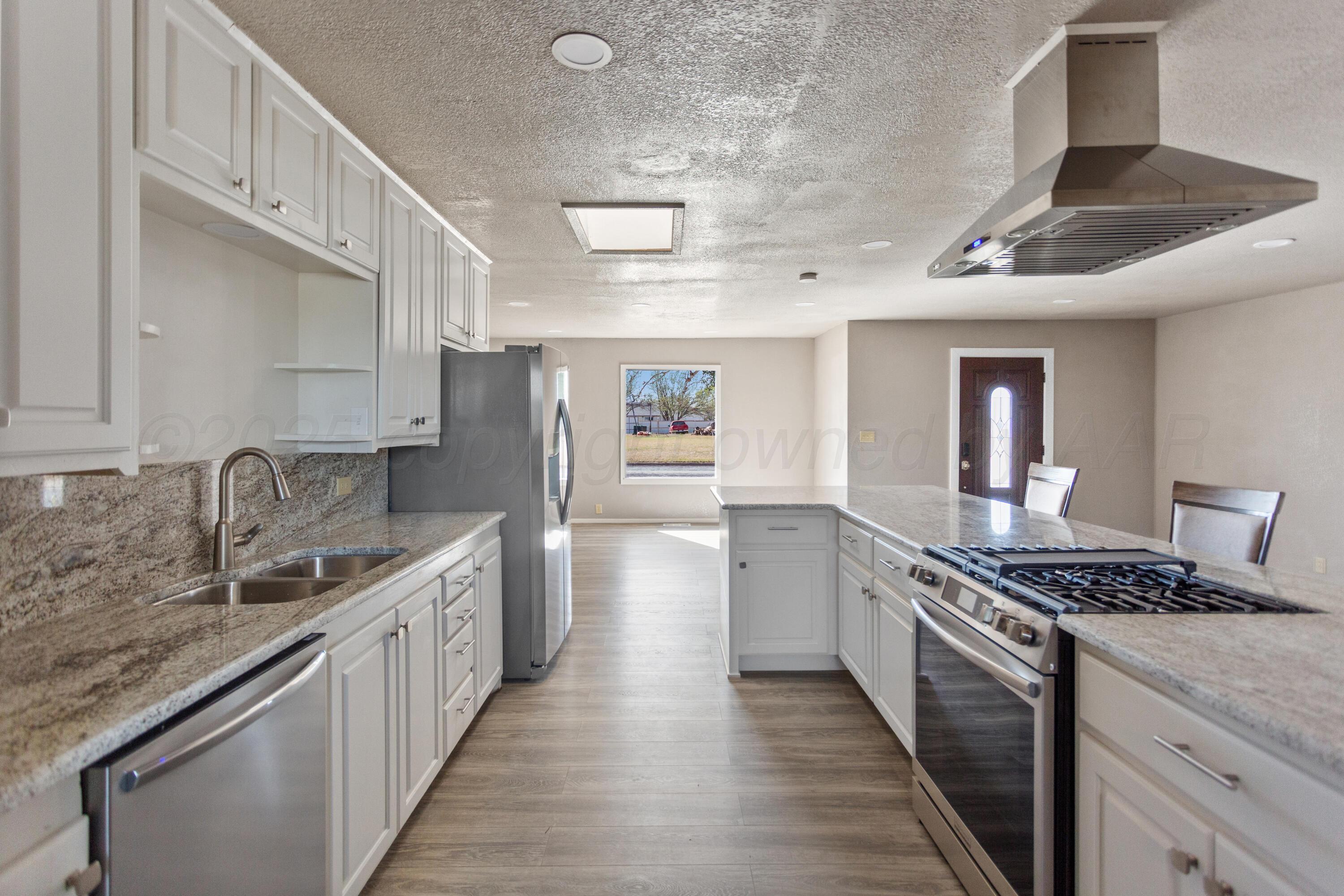 1119 South Main Street Wheeler, TX 79096 - Photo 9 of 49 a kitchen with stainless steel appliances granite countertop a sink stove and cabinets