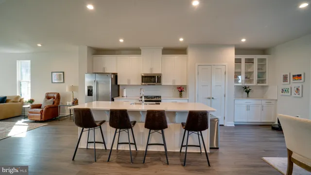 a view of kitchen with stainless steel appliances refrigerator stove dining table and chairs