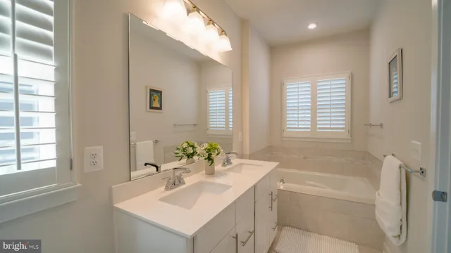 a bathroom with a bathtub sink and mirror