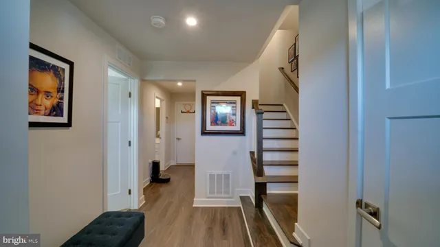 a view of hallway with stairs and wooden floor