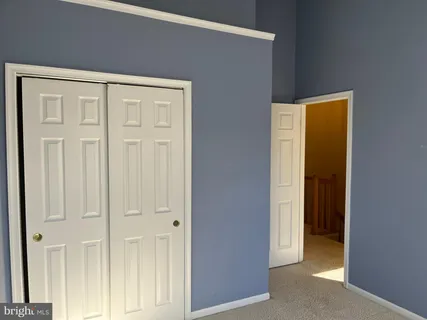 an empty room with wooden floor and closet area