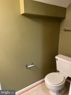 a white toilet sitting next to a white wall