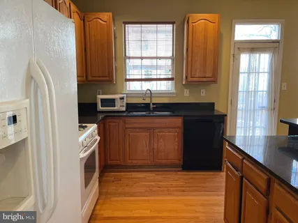 a kitchen with granite countertop a sink stove and refrigerator