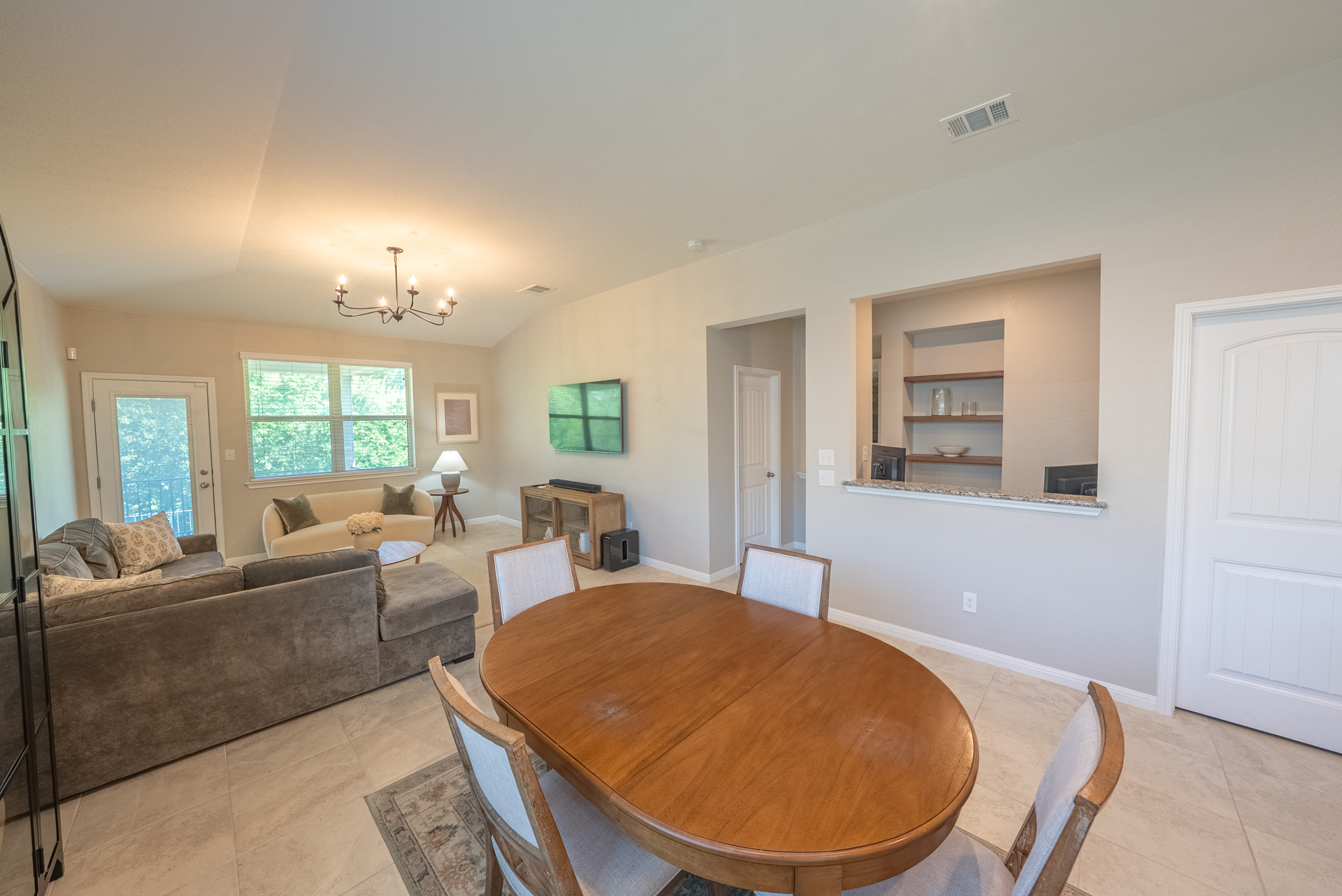 2508 Hat Bender Loop Round Rock, TX 78664 - Photo 8 of 22 Open-concept living area featuring vaulted ceilings, tile flooring, and a contemporary chandelier