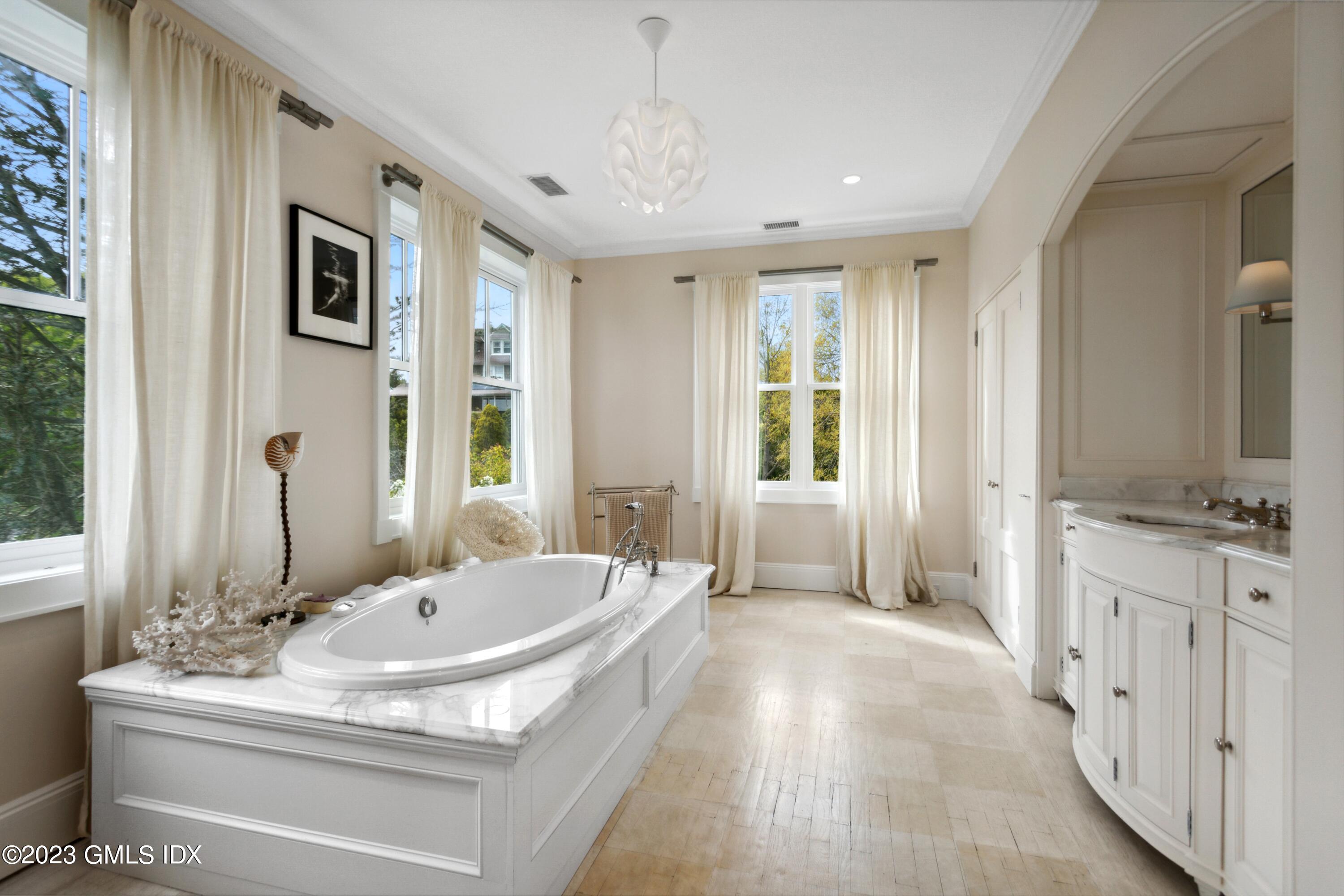 61 Byram Shore Road Greenwich, CT 06830 - Photo 21 of 36 a spacious bathroom with a tub sink and mirror
