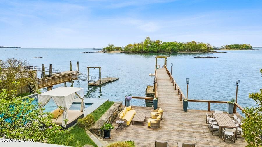 61 Byram Shore Road Greenwich, CT 06830 - Photo 27 of 36 a view of a lake with lawn chairs and a table