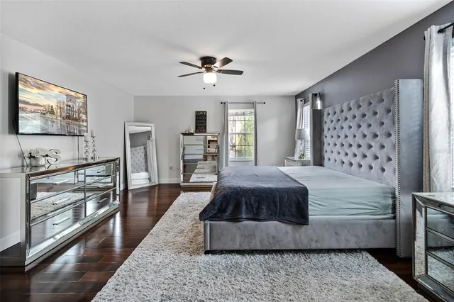 a bedroom with a large bed and a flat tv screen on dresser